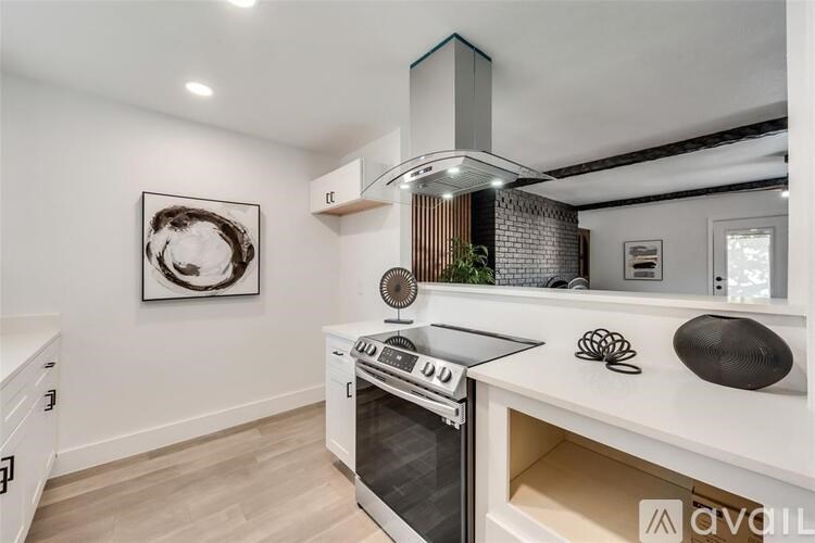 A modern kitchen with a white stove top oven and a black range hood.