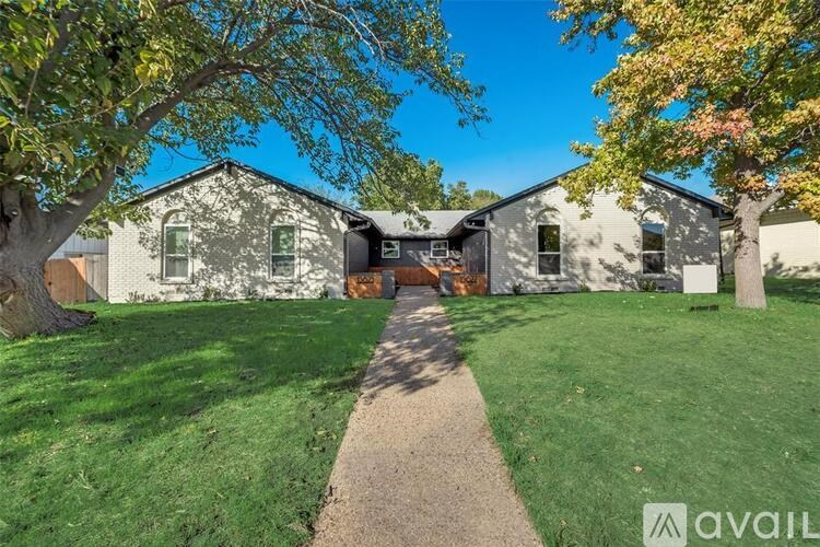 A house with a lawn and trees in front of it.