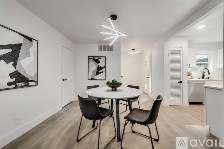 A dining room with a white table and chairs.