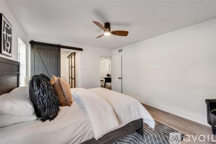 A bedroom with a bed, pillows, and a ceiling fan.