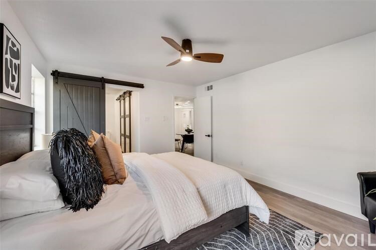 A bedroom with a bed, pillows, and a ceiling fan.