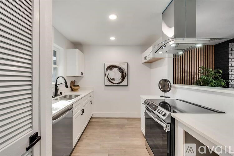 A modern kitchen with white cabinets and stainless steel appliances.