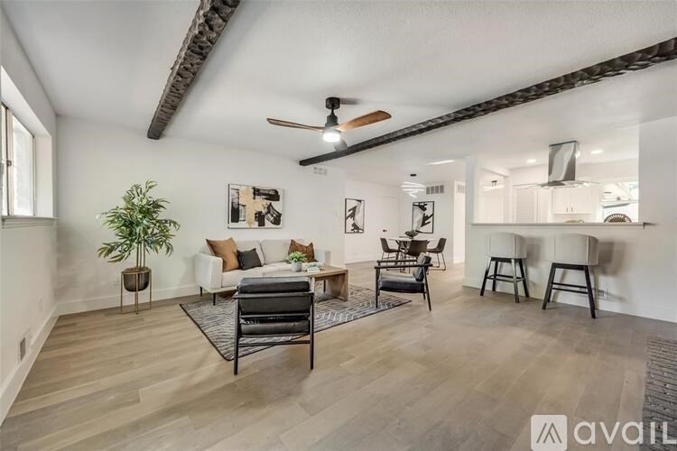 A living room with a black chair and a ceiling fan.