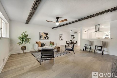 A living room with a black chair and a ceiling fan.