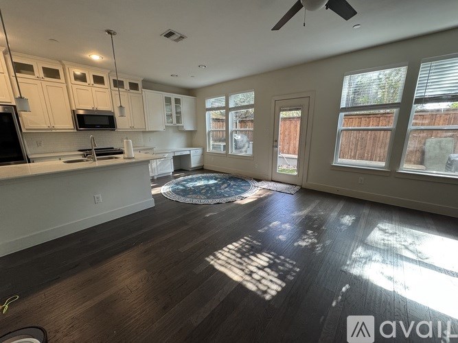 A sunny kitchen with a fan and a dining table.