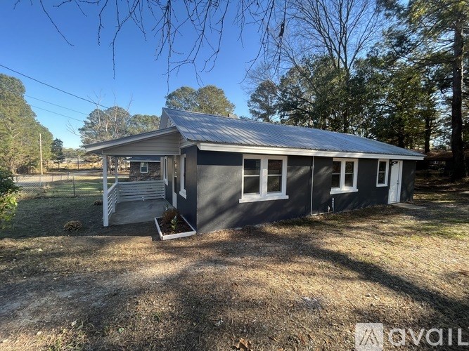 A small house with a metal roof and a porch.