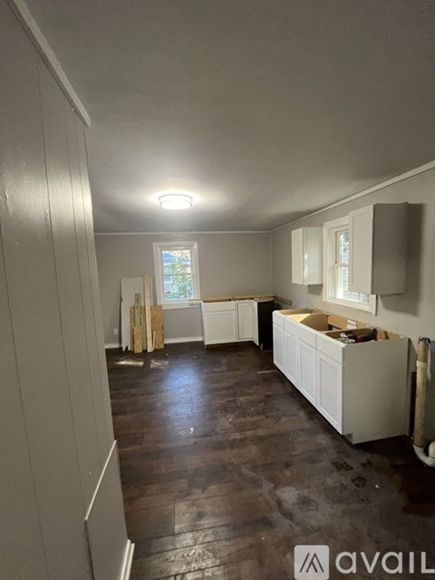 A kitchen with white cabinets and a window.