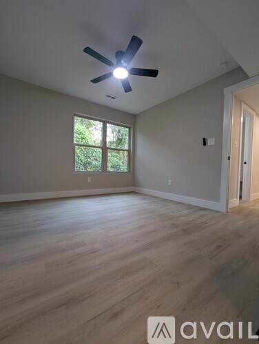 A room with a ceiling fan and a window.