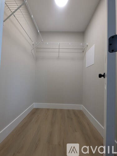 A room with a wooden floor and a door on the right side.