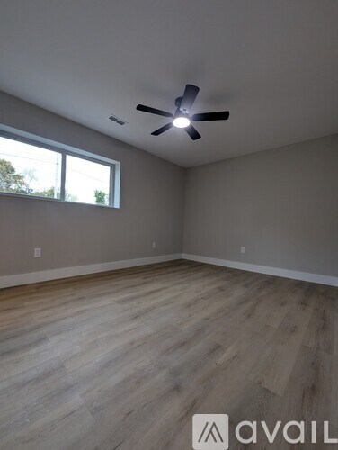 A room with a ceiling fan and a window.