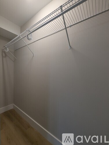 A long metal clothes hanger is hanging on a wall.