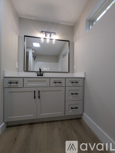 A bathroom vanity with a mirror and lights above it.
