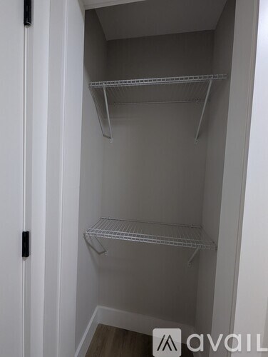 A white closet with three shelves and a black handle.