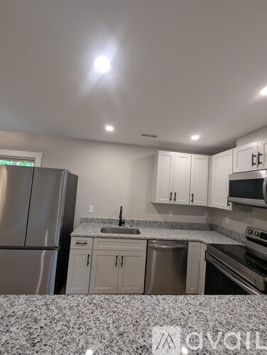 A kitchen with a refrigerator, microwave, dishwasher, and oven.