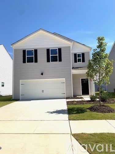 A house with a grey siding and a white garage door.