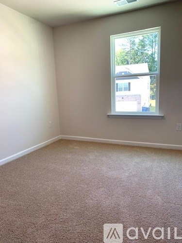 A room with a window and carpeted floor.