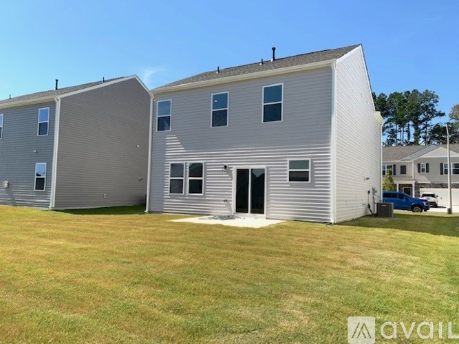 A row of houses with a car parked in front of the first one.