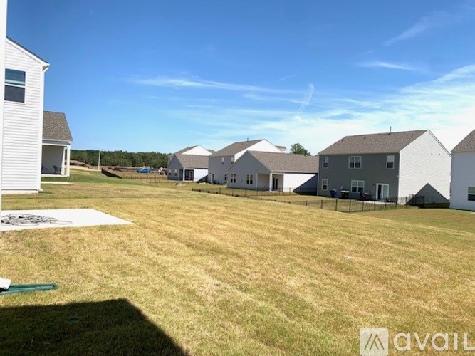 A row of houses with a field in front of them.
