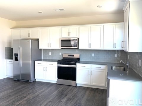 A kitchen with white cabinets and stainless steel appliances.