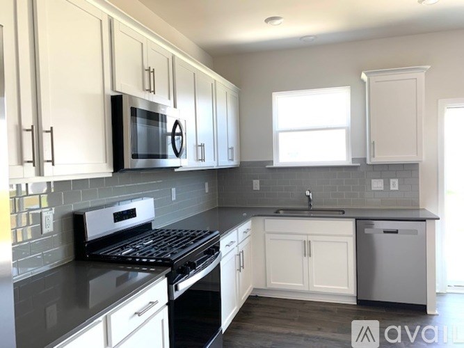 A kitchen with white cabinets and a black stove top oven.