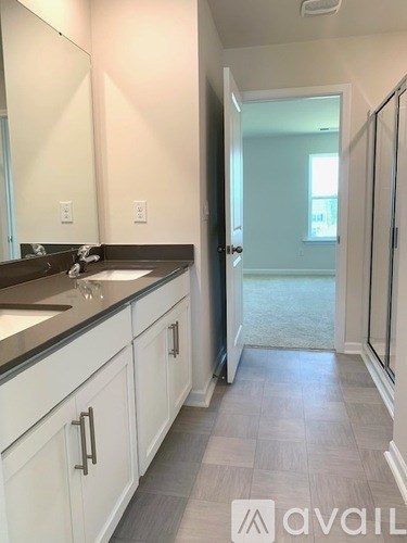 A bathroom with a sink, mirror, and tiled floor.