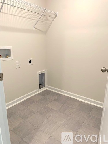 A room with a door, a window, and a shelf with bottles on it.