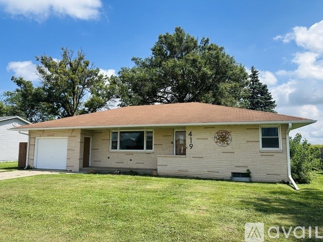 A house with a brown roof and a white garage door is for sale.