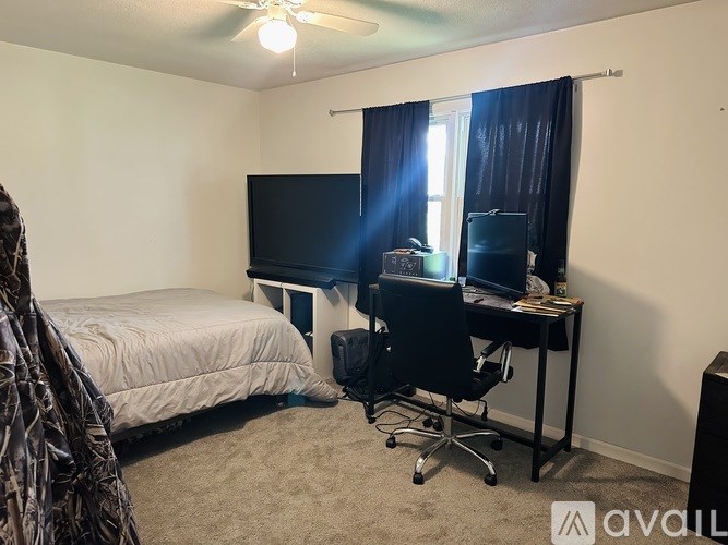 A bedroom with a bed, desk, and chair.