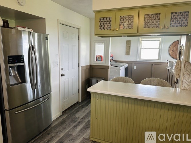 A kitchen with a stainless steel refrigerator and a white countertop.