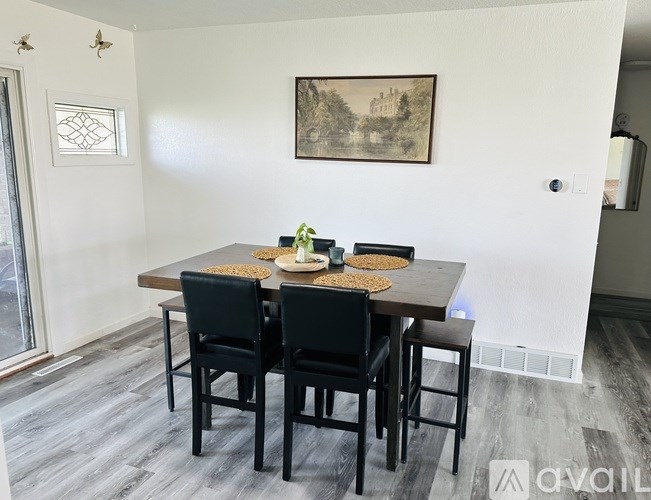 A dining room with a wooden table and chairs.