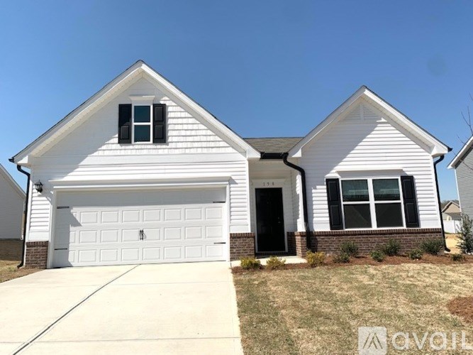 A white house with a garage door and a driveway in front.