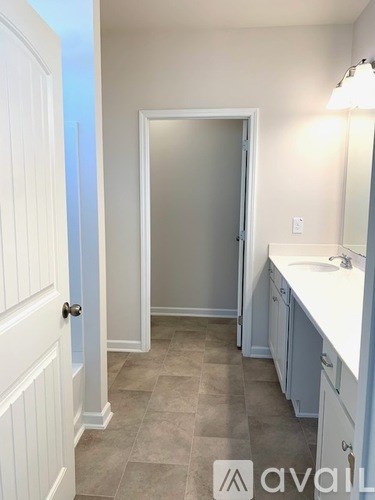 A bathroom with a white sink and a white door.