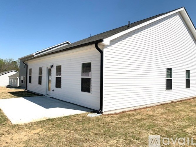 A white building with a black roof and a small porch.