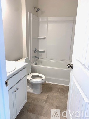 A white bathroom with a toilet, sink, and bathtub.