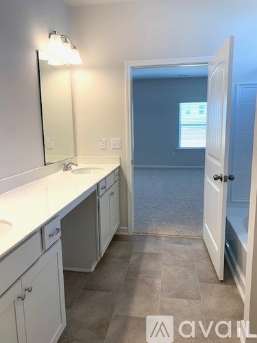 A bathroom with a white counter top and a white sink.