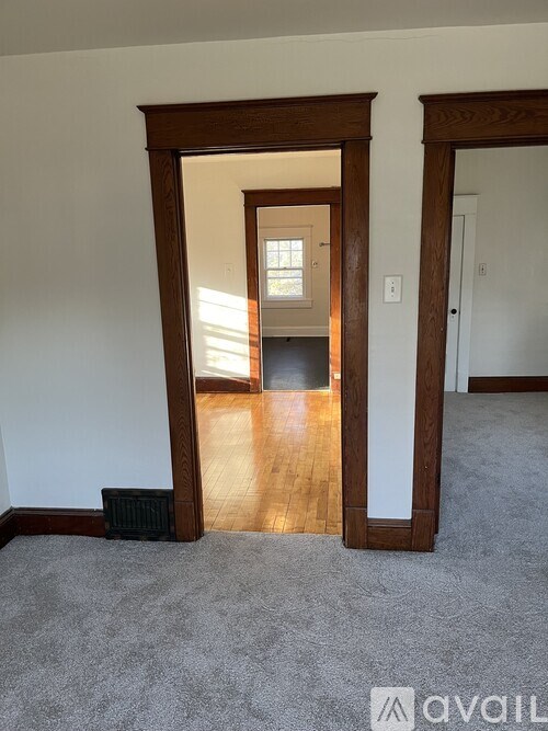 A room with a carpeted floor and a doorway leading to another room.