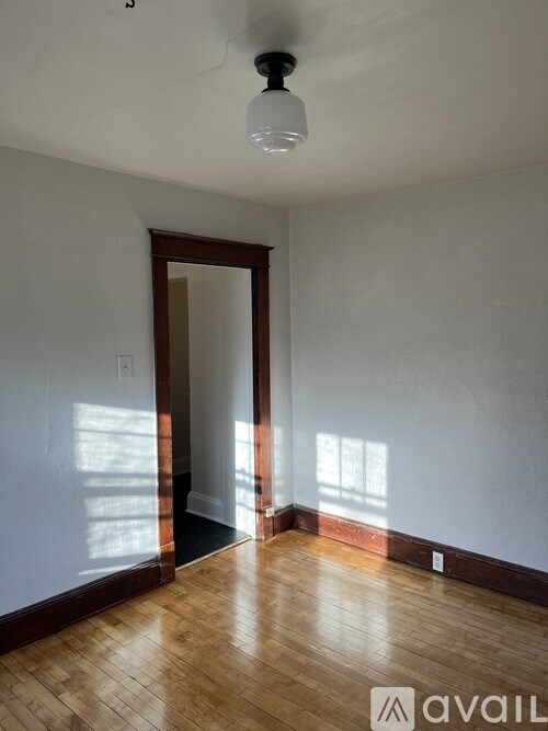 A room with wooden floors and a ceiling fan.