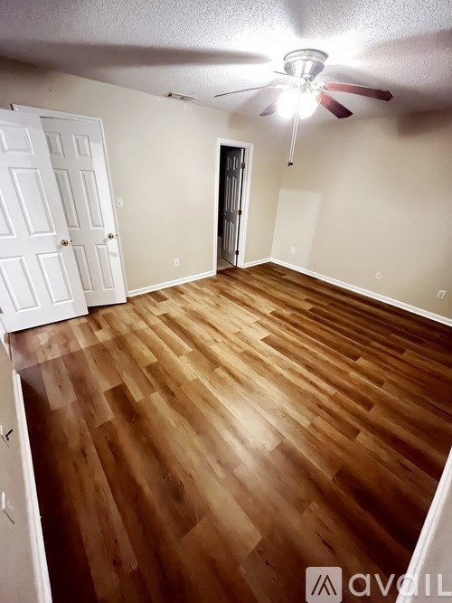 A room with wooden flooring and a ceiling fan.