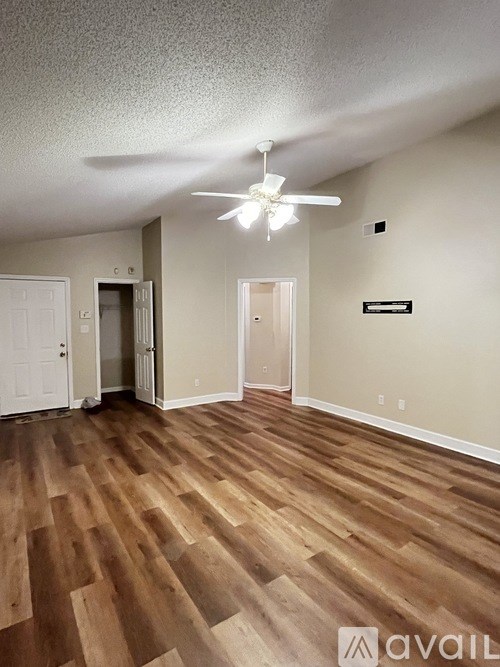 A room with wooden flooring and a ceiling fan.