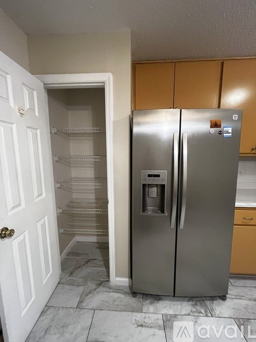 A stainless steel refrigerator with a water and ice dispenser in the middle of the door.