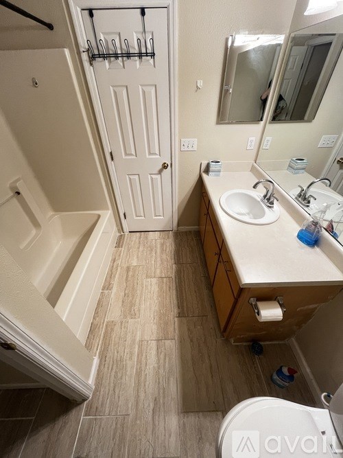 A bathroom with a white tub, sink, and toilet.