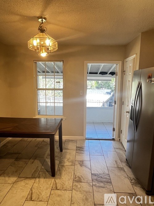 A kitchen with a table and a fridge.