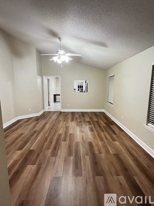 A room with wooden flooring and a ceiling fan.