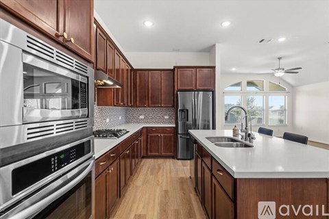 A modern kitchen with wooden cabinets and stainless steel appliances.