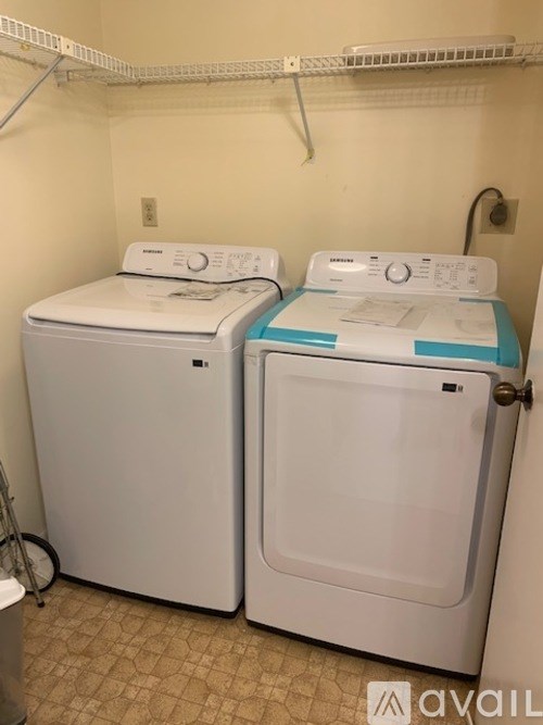 Two front loading washing machines in a small laundry room.