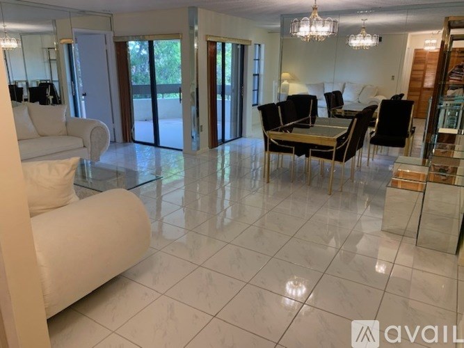 A spacious living room with a white sofa and a dining table set up.