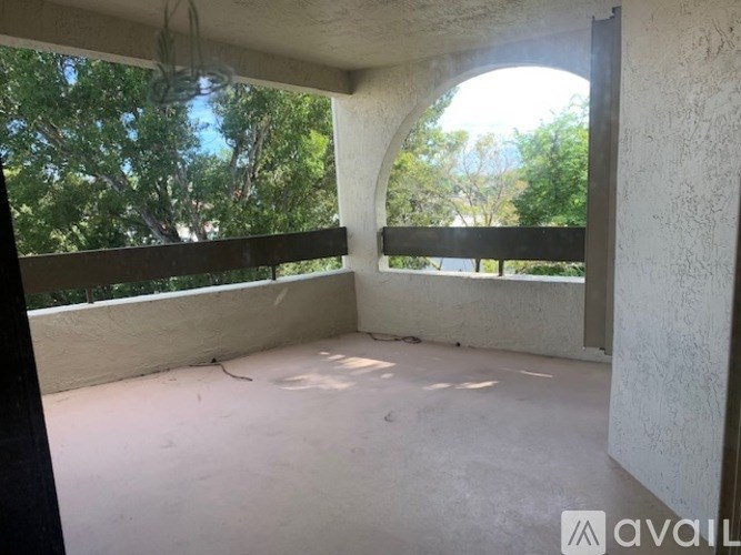 A room with a large arched window and a balcony railing.