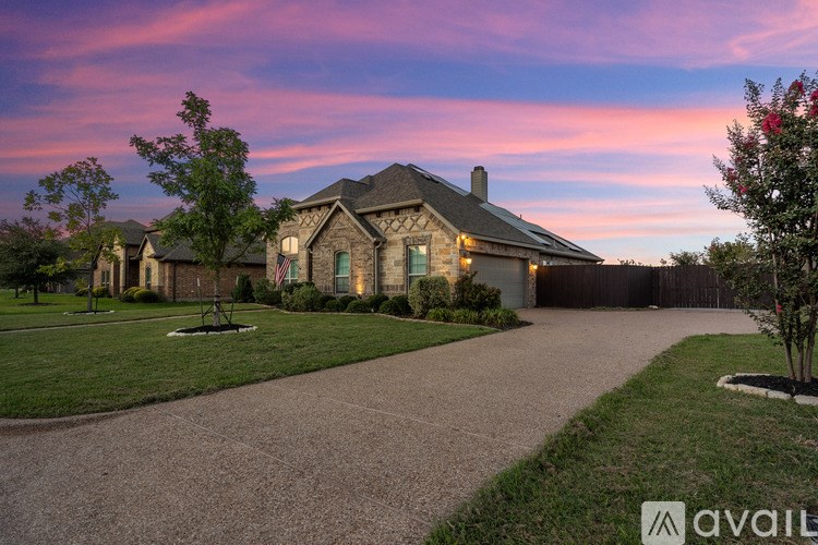 A house with a driveway and a tree in front of it.