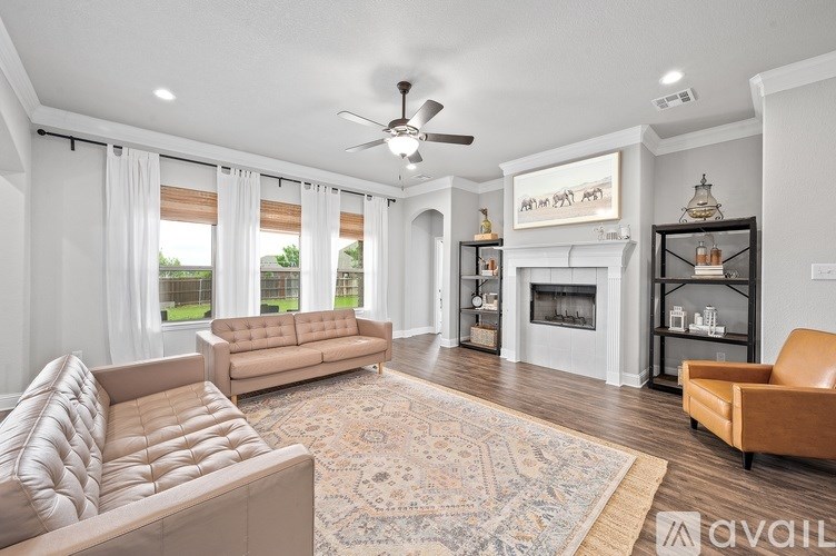 A living room with a beige sofa, a rug, and a fireplace.