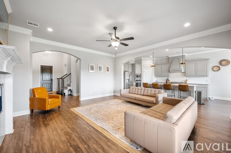A spacious living room with a yellow armchair and a beige sofa.